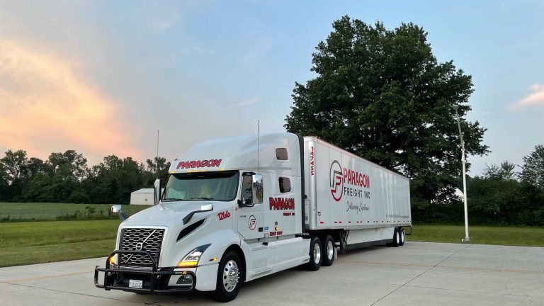 Paragon Freight Inc branded white trailer with Volvo truck on highway