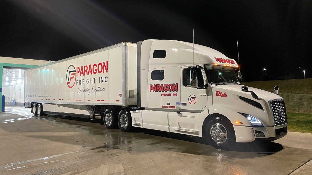 Paragon Freight white semi-truck and dry van trailer on the road